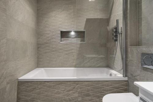 伊斯特雷格Modern 1 Bedroom Apartment in Central Eastleigh的带浴缸和卫生间的浴室。
