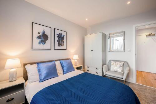 伊斯特雷格Cosy 1 Bedroom Apartment in the Heart of Eastleigh的一间卧室配有蓝色的床和椅子