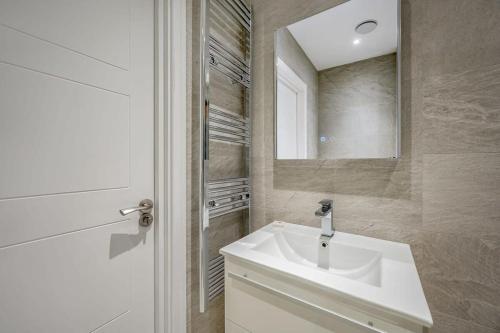 伊斯特雷格Cosy 1 Bedroom Apartment in the Heart of Eastleigh的浴室设有白色水槽和镜子
