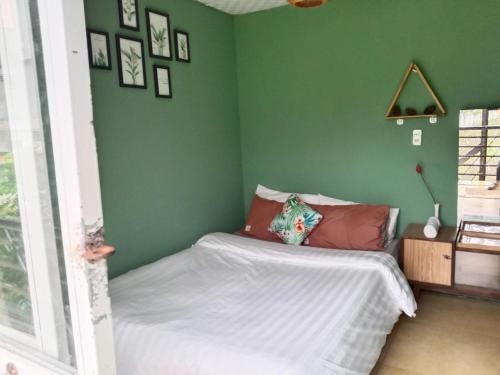 大叻Dalat Inn ez home的一间小卧室,拥有绿色的墙壁和一张床