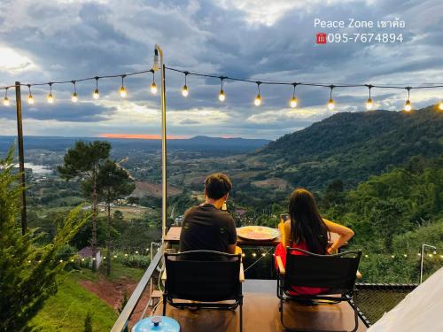 考科Peace Zone เขาค้อ的一对夫妇坐在桌子上,眺望着群山