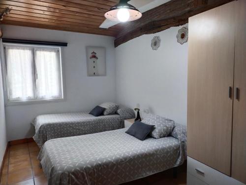 穆特里库ANTZOMENDI的一间卧室设有两张床和窗户。