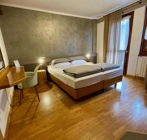 蓬泰迪莱尼奥Hotel Garni Sorriso的一间卧室设有一张床和一个大窗户