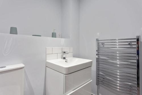 伯明翰Stunning 1br flat in Birmingham的白色的浴室设有水槽和橱柜