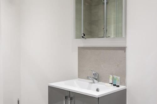 利兹Cosy & Modern 1 Bed Apartment Leeds的白色的浴室设有水槽和镜子