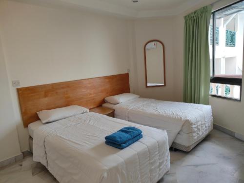波德申BAYU BEACH RESORT的酒店客房,设有两张床和镜子