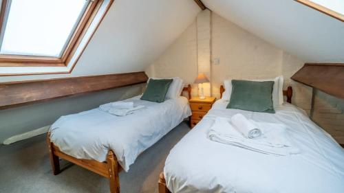 布德Charming 3 Bedroom Holiday Cottage nr Bude的带窗户的客房内设有两张单人床。