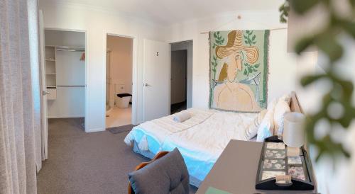 汉密尔顿Waikato Uni guest room with private bathroom的一间卧室配有一张床和一张桌子
