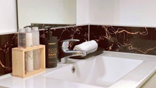 汉密尔顿Waikato Uni guest room with private bathroom的浴室水槽配有水龙头和洗浴用品。