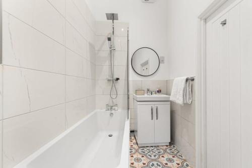 沃金Lovely 1 Bedroom Apartment in Woking Centre的白色的浴室设有浴缸和水槽。