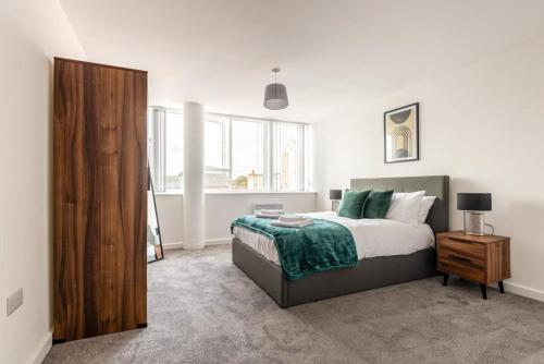 雷特福德Contemporary 1 Bed Apartment in Central Retford的一间卧室配有一张床和一个木制橱柜