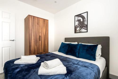 利兹Smart 1 Bedroom Apartment in Leeds的一间卧室配有蓝色的床和毛巾