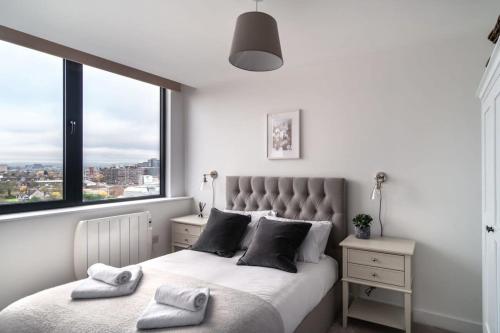 曼彻斯特Lovely Modern 1 Bed Apartment by Old Trafford的一间卧室设有一张大床和大窗户
