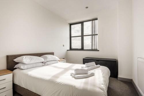 巴恩斯利Modern 1 Bedroom Budget Apartment in Barnsley的卧室配有带毛巾的大型白色床