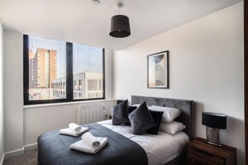 曼彻斯特Modern & Spacious 1 Bed Apartment - Old Trafford的一间卧室配有一张床,上面有两条毛巾