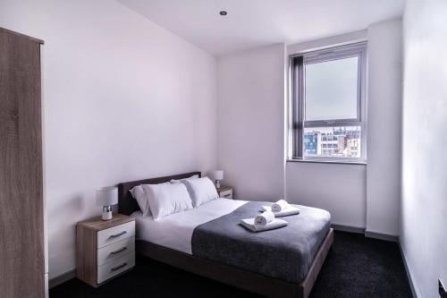 布莱克本Contemporary 1 Bed Apartment in Central Blackburn的白色的卧室设有床和窗户