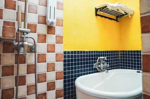 鹅銮鼻垦丁迦南美地-海景花园民宿的浴室设有卫生间和黄色及蓝色的墙壁。