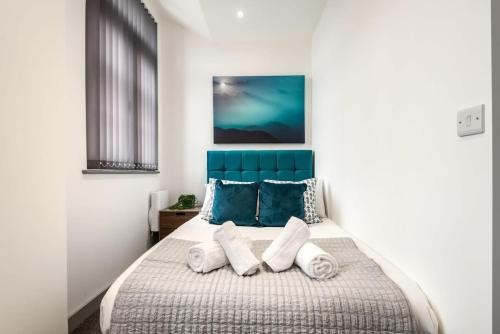 唐克斯特1 Bedroom Budget Apartment in Central Doncaster的一间卧室配有一张带蓝色床头板和枕头的床。