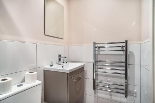 曼彻斯特Modern & Bright 2 Bed Apartment in Manchester的白色的浴室设有水槽和镜子