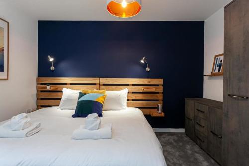 曼彻斯特Stunning 2 Bed Flat 5min to Old Trafford Stadium的一间卧室设有一张蓝色墙壁的大床