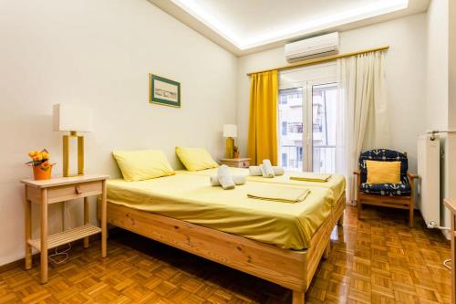 雅典Athens Perfect Spot - Zografou Cozy Home的一间卧室配有一张带黄色床单的大床