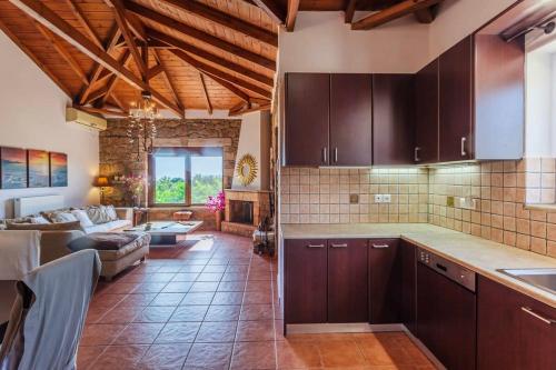 KotrónionMani's Aura Seaside-Spacious Summer Retreat的一间带棕色橱柜的厨房和一间客厅