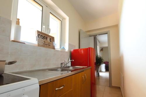 斯卡费迪亚Skafidia Seaview Retreat - Orpheas Seaview Home的厨房配有水槽和红色冰箱