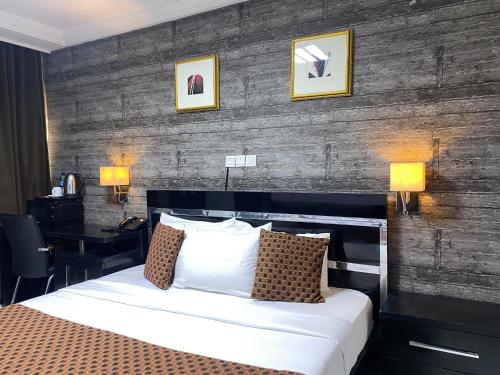 阿布贾Newland Luxury Hotels and Apartments的配有一张床和一张书桌的酒店客房