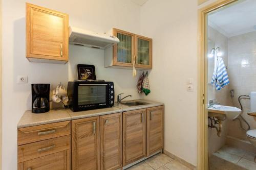 卡拉马塔Kalamata City Nest - Central & Cozy Hideout的一个带水槽的厨房和一台台面上的电视