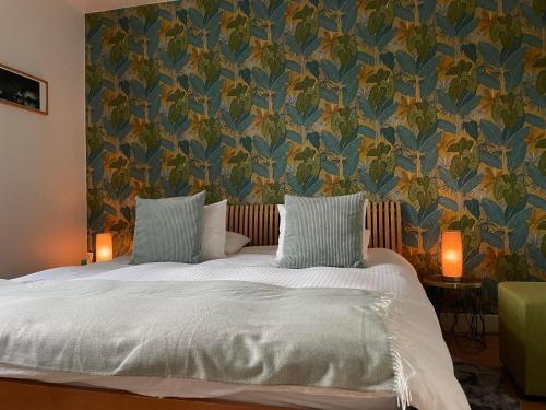 那慕尔La Majolique的一间卧室配有一张带花卉壁纸的床