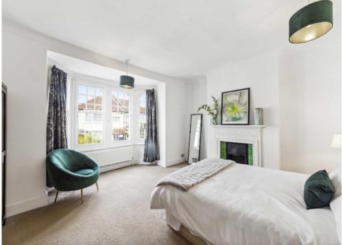 Streatham ValeArragon的一间卧室配有一张大床和一张绿色椅子