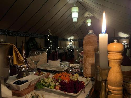 梅尔祖卡Merzouga Stars Luxury Camp的一张带蜡烛和一盘食物的桌子