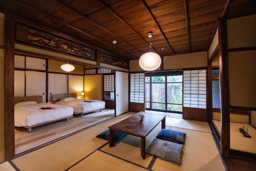 奈良NIPPONIA HOTEL NARA NARAMACHI的一间卧室配有两张床和一张桌子。