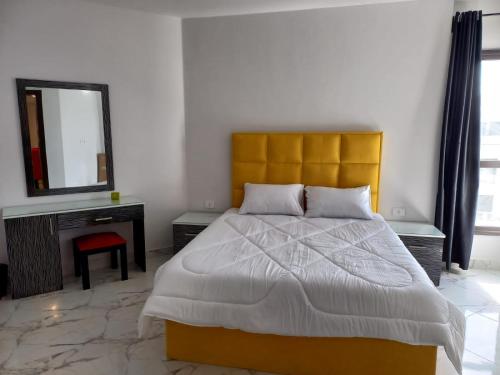 塞得港شاليهات فندقيه بورتوسعيد的一间卧室配有一张大床和镜子