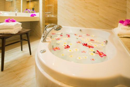 塞班Aqua Resort Club Saipan的浴室内装有鲜花的浴缸