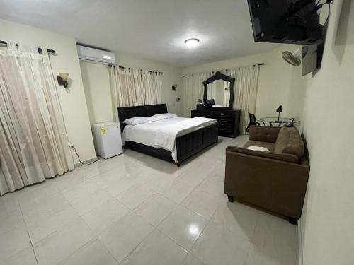 HigueyMaria's Entire House HIGUEY 2BD的一间卧室配有一张床、一张沙发和一台电视