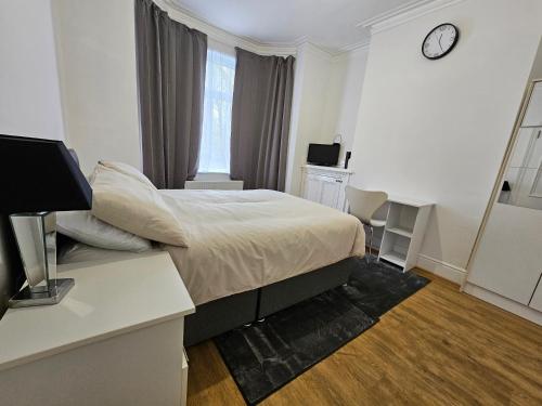 曼彻斯特Stylish & Quiet Space的一间卧室配有一张床、一张桌子和闹钟