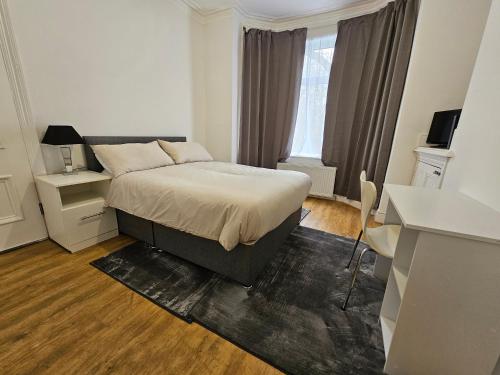 曼彻斯特Stylish & Quiet Space的一间卧室配有一张床、一张书桌和一个窗户。