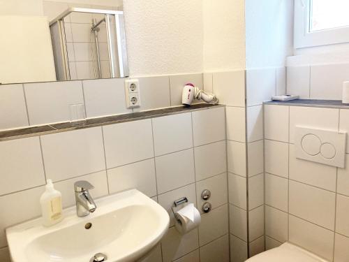 黑尔戈兰岛Haus Hanseatic的白色的浴室设有水槽和镜子