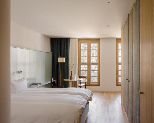 布雷根茨kleiner Löwe – Stadthotel Bregenz的酒店客房设有一张大床和一张桌子。
