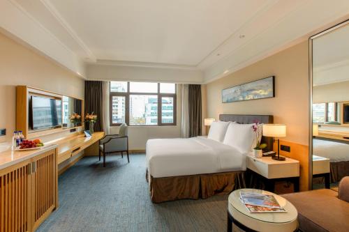 厦门厦门湖里颐豪酒店的酒店客房设有一张大床和一张书桌。