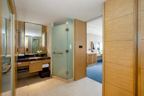 厦门厦门湖里颐豪酒店的一间带玻璃淋浴和水槽的浴室