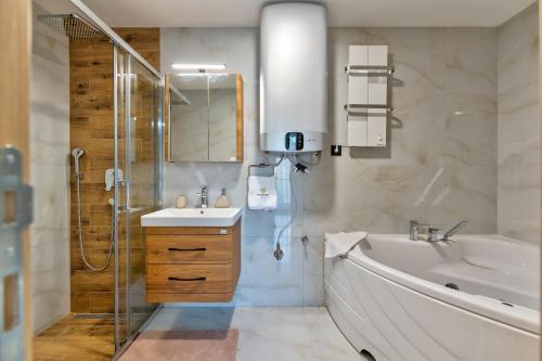 兹拉蒂博尔Golden Panorama Spa & Wellness的一间带水槽、浴缸和淋浴的浴室