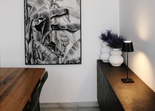 布林迪西Alivi Indipendent Apartment的客厅配有桌子和墙上的绘画