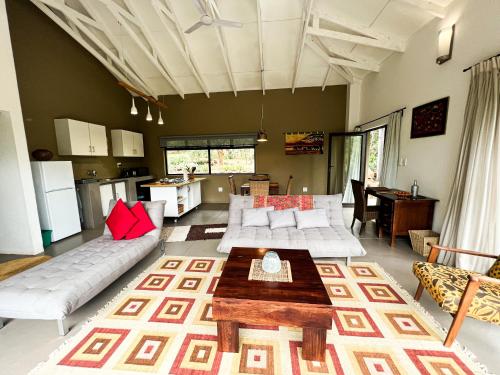 Kampersrus AHUkuthula Cottages的客厅配有白色的沙发和桌子