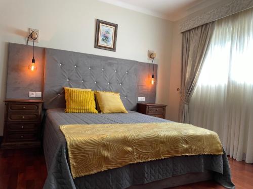 旧阿尔贝加里亚Cozy Guest House Albergaria的一间卧室配有一张带黄色枕头的大床