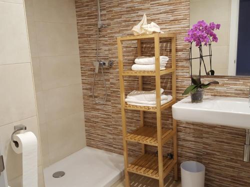 卡拉费尔Mandala apARTments的浴室设有水槽旁的竹毛巾架