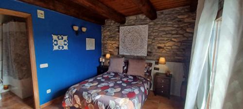 菲斯卡尔Cimas con historia的一间卧室配有一张蓝色墙壁和石墙的床。