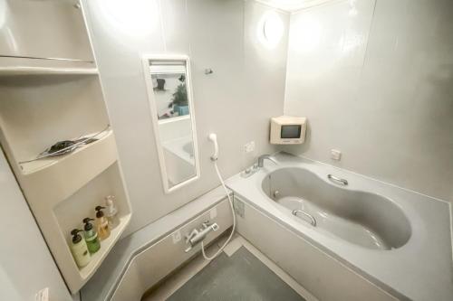 仙台ホテル　るテラスⅡ的白色的浴室设有浴缸和镜子