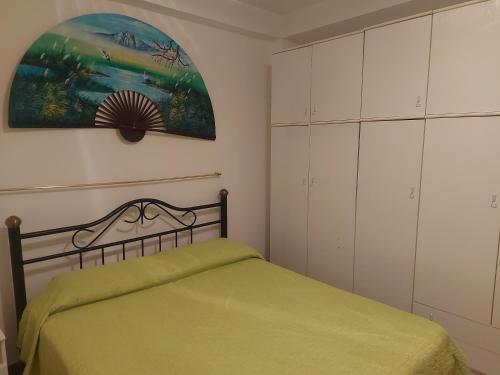 拉古萨码头A casa di Franco的一间卧室配有一张绿色的床和白色的橱柜。